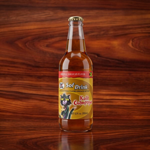 A bottle of Sof Drink Kola Champagne, an original Jamaican flavored soda, on a wooden surface.